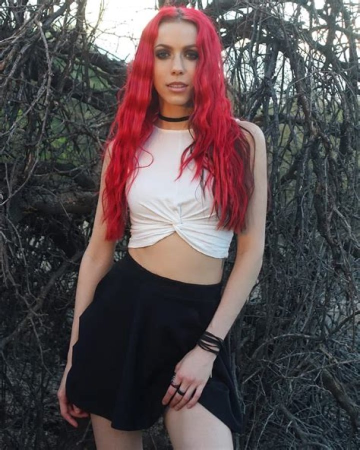 Krystle Amina with her red Ford Mustang pose for a picture.