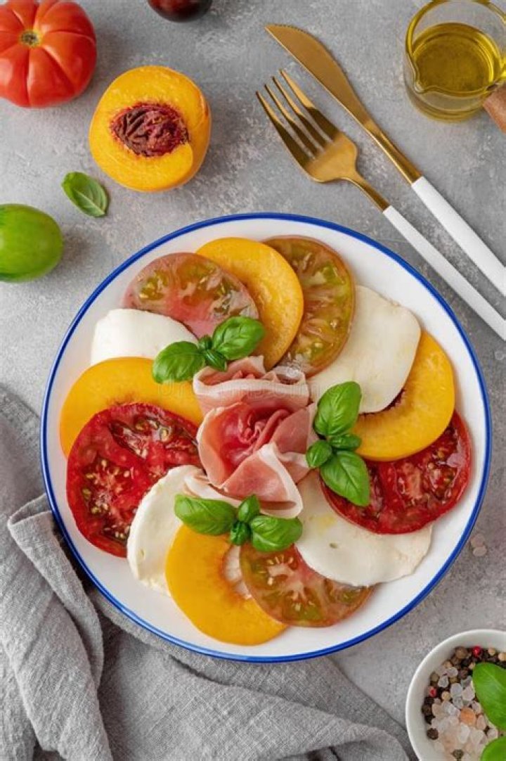 Sliced peaches, tomato, and mozzarella topped with basil.