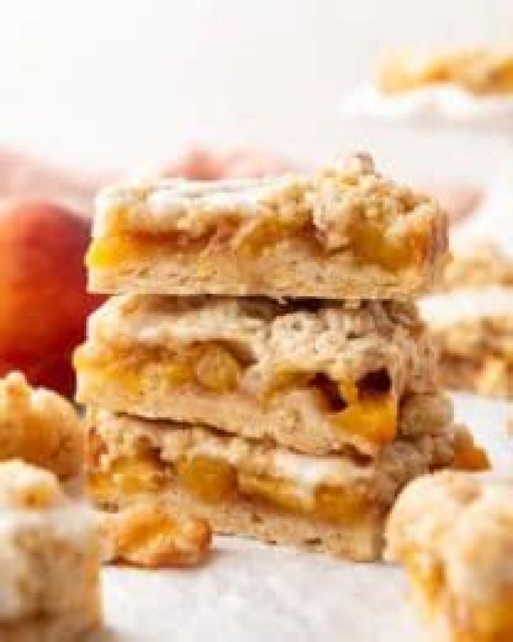 Stack of Peach Crumb Bars on a white plate.
